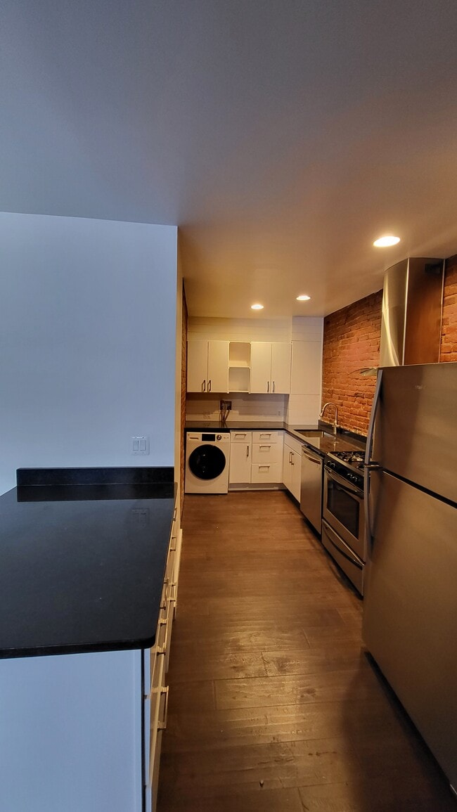 Preciosa cocina con lavandería integrada, encimeras de granito y electrodomésticos de acero inoxidable. - 403 N Charles St