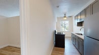 Located in the vibrant Koreatown neighborhood of Los Angeles, this single-story unit at 437 N Ardmore Ave offers a thoughtfully updated interior with a cohesive modern aesthetic throughout. Light wood-tone flooring runs continuously across the space, creating a warm and unified feel.

The galley-style kitchen is well-appointed with grey shaker cabinetry, brushed nickel hardware, white quartz countertops, a stainless steel sink, a gas range, and a black refrigerator. Recessed lighting and a window at the far end provide both functionality and natural light. A ceiling fan adds comfort to the adjoining area.

The bathroom features dark, large-format tile surrounds in the tub-shower combination, a dark-finished vanity with an integrated sink, and a framed mirror, delivering a clean, contemporary contrast to the light flooring. A bright window in the adjacent room allows generous natural light to filter through.

The bedrooms are bright and airy, with clean white walls, crown molding details, and ample closet space. One bedroom includes a distinctive sliding barn door, adding a modern farmhouse design element, along with access to a dedicated walk-in closet. Additional panel doors provide further storage flexibility. The overall layout is efficient and well-organized, making this Los Angeles unit a comfortable and stylish place to call home.