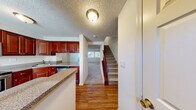 Located at 1401 Eland Downe in Phoenixville, PA, this two-bedroom, two-bathroom home spans two floors with a well-designed layout that maximizes every inch of its living space. The main level features warm hardwood flooring throughout the open kitchen and living area. The kitchen is a standout, outfitted with rich cherry wood cabinetry, granite-style countertops, and a full suite of stainless steel appliances including an electric range, built-in microwave, dishwasher, and refrigerator. A window above the sink brings in natural light, while a breakfast bar-style counter connects the kitchen to the living area. A carpeted staircase leads to the upper level, where both bedrooms are finished with plush wall-to-wall carpet and textured ceilings. The spacious primary bedroom includes dual closets and a window allowing natural light to fill the room. The second bedroom is comfortably sized and similarly appointed. Both bathrooms are clean and functional, featuring tub-shower combinations with white surrounds and brushed nickel fixtures. Hallways on each floor provide easy circulation throughout the home, and the layout offers a practical, efficient flow well-suited for everyday living.