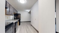 Located at 1267 11th Ave SW in Forest Lake, MN, this one-bedroom, one-bathroom unit offers a practical and comfortable single-floor layout. Light-toned vinyl plank flooring runs throughout the main living areas, complementing the clean white walls and dark baseboards that give the space a modern, cohesive look.

The kitchen is efficiently designed and features dark cabinetry, granite-look countertops, a double-basin stainless steel sink, and black appliances including a full-size refrigerator and electric range. A textured ceiling adds subtle character to the kitchen area.

The living room is open and bright, with a window unit air conditioner and baseboard heating, ensuring year-round comfort. A window allows natural light to filter in, offering views of the surrounding neighborhood.

The bedroom is a generously sized retreat finished with plush carpet, a ceiling fan with integrated lighting, a window for natural light, and a sliding-door closet offering ample storage. Baseboard heating ensures warmth throughout the cooler Minnesota months.

The bathroom is clean and well-lit, featuring a granite-top vanity, a lighted mirror, a tub-shower combination, and vinyl plank flooring. A connecting hallway ties all rooms together, creating a logical and efficient flow throughout the unit.