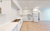 Located at 1520 Hecker Pass Hwy in Gilroy, California, Unit 3106 is a thoughtfully designed single-story residence that offers a clean, modern aesthetic throughout. Light wood-tone flooring runs continuously across the entire unit, creating a cohesive and bright atmosphere in every room.

The kitchen is well-appointed with ample white cabinetry extending to the ceiling, generous countertop space, white appliances including a range, refrigerator, and dishwasher, and a stainless steel sink. Recessed lighting and a wall-mounted mini-split HVAC unit provide functional comfort. The kitchen flows naturally into the open living area, which benefits from natural light through windows fitted with horizontal blinds offering views of the surrounding neighborhood.

The bedroom features a wall-mounted mini-split unit for independent climate control, a large sliding door closet spanning nearly the full width of the wall, and a window that brings in additional natural light. Additional rooms in the unit offer clean, open spaces with white walls and continued light wood flooring.

The bathroom is designed with accessibility in mind, featuring multiple grab bars along the walls, a roll-under vanity with an integrated sink, and a combination tub and shower. Throughout the unit, the consistent use of white walls and light flooring creates a bright, airy, and welcoming environment.