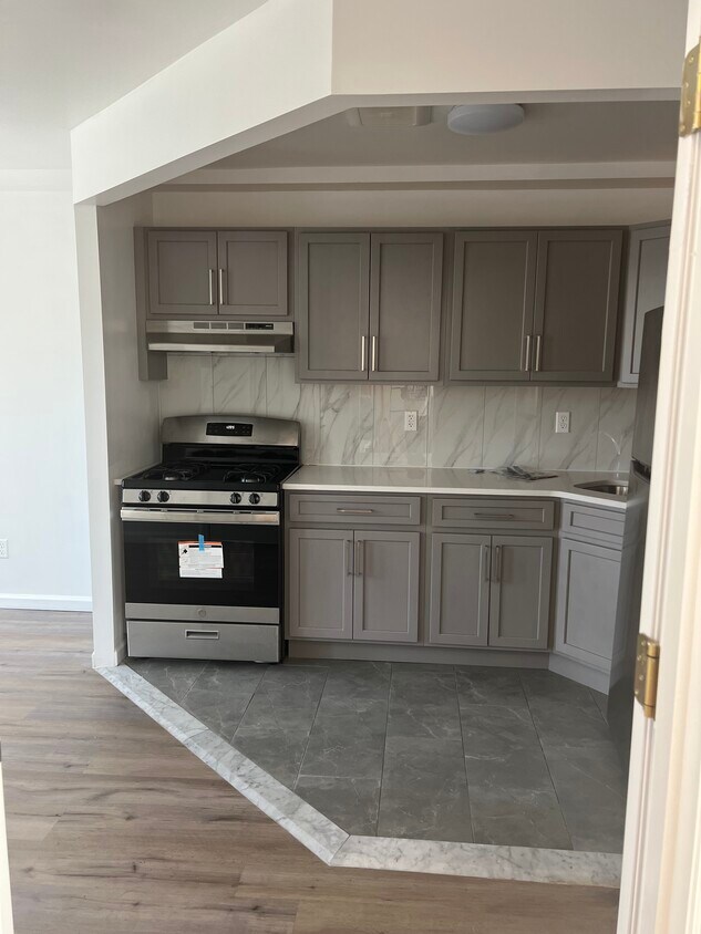 Open kitchen layout complete with countertops and rich wooden cabinetry - 1835 Atlantic Ave