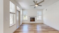 This thoughtfully designed single-story home offers a comfortable and modern living experience across two bedrooms, two bathrooms, and a well-organized floor plan. The bright and airy living area serves as the heart of the home, featuring light hardwood-style flooring, a sleek electric fireplace framed by a clean white mantle, and multiple windows dressed with blinds that allow abundant natural light to fill the space. A ceiling fan overhead adds both style and functionality to the room.

The kitchen is outfitted with white shaker cabinetry, granite countertops, a classic subway tile backsplash, and stainless steel appliances, including a range, microwave, and refrigerator — offering a clean, contemporary aesthetic. Light hardwood flooring continues throughout the main living areas.

Both bedrooms feature plush wall-to-wall carpeting and generous natural light from large windows with exterior views. Each bedroom benefits from its own closet, with walk-in shelving systems providing practical storage. The two bathrooms are finished consistently with white cabinetry, granite countertops, and marble-style tiled tub-shower combinations with brushed nickel fixtures. A dedicated laundry room with overhead shelving and in-unit washer hookups adds everyday convenience to this well-rounded home.