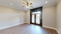 Located at 1230 Cottontown Rd in Forest, VA, this single-floor residence offers a thoughtfully designed layout across a comfortable footprint. The open-concept kitchen and living area serves as the heart of the home, showcasing stylish gray shaker cabinets, a white quartz countertop island with an undermount sink, stainless steel appliances, a subway tile backsplash, and pendant lighting — all complemented by durable hardwood-style flooring. The living area features crown molding, recessed lighting, a ceiling fan, and striking dark-framed French doors with transom windows that invite abundant natural light. The spacious primary bedroom is finished with plush carpet, a ceiling fan, and generous proportions that provide a comfortable retreat. The full bathroom includes a tub/shower combo, a gray vanity with white countertop, and elegant marble-style tile flooring. A dedicated laundry room accommodates a full-size washer and dryer with an overhead shelf for added storage. Neutral tones, crown molding, and clean white baseboards throughout lend the space a cohesive, modern aesthetic. A hallway and closet round out the practical, efficiently organized floor plan.