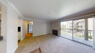 Located at 1757 Mill Springs Common in Livermore, California, this single-story residence offers a thoughtfully designed layout with a blend of hardwood-style flooring and plush carpeting throughout. The spacious living room is a standout, anchored by a tile-surround fireplace and bathed in natural light from large sliding glass doors that open to a private balcony with pleasant outdoor views. Crown molding adds a refined architectural detail to the living and dining areas.

The open-concept kitchen features white cabinetry, dark countertops, stainless steel appliances including a microwave and range, and a peninsula with a undermount sink — all seamlessly connected to the dining area via a pass-through layout. A skylight enhances the brightness of this central hub.

The bedrooms are carpeted and well-sized, each benefiting from natural light through large windows. One bedroom includes direct access to a bathroom with a tiled tub-shower combination, a single vanity with dark countertop, and hardwood-style flooring. An additional bathroom features a stylish blue vanity, updated fixtures, and convenient access to a walk-in closet with wire shelving. The overall ambiance is clean, neutral, and move-in ready.