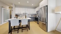 Located at 121 N 2nd St in Philadelphia's historic Old City neighborhood, this modern 2-bedroom, 2-bathroom apartment spans 780 square feet across a single floor. The open-concept living room features large floor-to-ceiling windows that flood the space with natural light and offer views of the surrounding urban streetscape. Light hardwood flooring runs throughout, complementing the unit's clean, contemporary aesthetic.

The well-appointed kitchen is equipped with stainless steel appliances, two-toned cabinetry featuring white uppers and slate-gray lowers, white quartz countertops, a subway tile backsplash, and recessed lighting. A dining table with seating provides an ideal space for casual meals.

The primary bedroom measures 150 square feet and includes large windows and a dedicated walk-in closet with built-in wire shelving. The second bedroom also benefits from generous natural light. Both bathrooms feature large-format gray tile flooring, glossy gray vanity cabinetry, white quartz countertops, and illuminated mirrors. One bathroom includes a soaking tub. A dedicated closet provides additional storage throughout the unit.