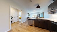 Located at 713 Bloomfield Ave in Bloomfield, Connecticut, this well-appointed single-floor residence offers a thoughtfully designed open-concept layout that seamlessly connects the kitchen, dining, and living areas. The space is finished with warm light wood-tone flooring throughout the main areas, creating a cohesive and inviting atmosphere.

The kitchen is a standout feature, outfitted with dark espresso cabinetry, a full suite of stainless steel appliances including a refrigerator, electric range, microwave, and dishwasher, complemented by a white countertop peninsula with bar seating. Under-cabinet lighting and a classic white tile backsplash add a clean, modern touch.

The living room is generously proportioned, filled with natural light from large windows that frame outdoor views of the surrounding neighborhood. The space comfortably accommodates a full seating arrangement, making it ideal for relaxing or entertaining.

The bedrooms are carpeted for comfort and feature large windows that bring in ample natural light, with views extending to an outdoor balcony area. The bathroom is clean and functional, with wood-tone flooring carried throughout. An efficient and practical floor plan ensures every area of this residence is well-utilized, making it a comfortable and modern home.