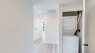 Located at 3660 Reynard Way in San Diego's vibrant Mission Hills neighborhood, this modern single-floor unit offers 1 bedroom and 2 bathrooms within a thoughtfully designed layout. The space showcases an industrial-modern aesthetic defined by exposed concrete ceilings, crisp white walls, and light wood-tone flooring throughout.

The open-concept living and kitchen area is a standout, featuring dramatic floor-to-ceiling windows with black metal frames that flood the space with natural light and frame lush, green outdoor views. The kitchen is equipped with stainless steel appliances—including a refrigerator, range, microwave, and dishwasher—complemented by light wood cabinetry and a concrete-toned backsplash.

The bedroom continues the clean, minimalist aesthetic with white walls, light flooring, and exposed concrete ceiling accents, offering a cozy yet modern retreat. Both bathrooms are finished consistently with the rest of the unit, featuring light wood cabinetry, matte black fixtures and hardware, floating vanities, and the same warm wood-tone flooring. A hallway connects the spaces efficiently, contributing to the unit's practical flow.

Overall, the space presents a cohesive urban design sensibility, balancing raw industrial elements with warm, contemporary finishes in a well-connected San Diego location.