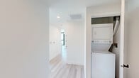 Located at 3660 Reynard Way in San Diego's vibrant Mission Hills neighborhood, this modern single-floor unit offers 1 bedroom and 2 bathrooms within a thoughtfully designed layout. The space showcases an industrial-modern aesthetic defined by exposed concrete ceilings, crisp white walls, and light wood-tone flooring throughout.

The open-concept living and kitchen area is a standout, featuring dramatic floor-to-ceiling windows with black metal frames that flood the space with natural light and frame lush, green outdoor views. The kitchen is equipped with stainless steel appliances—including a refrigerator, range, microwave, and dishwasher—complemented by light wood cabinetry and a concrete-toned backsplash.

The bedroom continues the clean, minimalist aesthetic with white walls, light flooring, and exposed concrete ceiling accents, offering a cozy yet modern retreat. Both bathrooms are finished consistently with the rest of the unit, featuring light wood cabinetry, matte black fixtures and hardware, floating vanities, and the same warm wood-tone flooring. A hallway connects the spaces efficiently, contributing to the unit's practical flow.

Overall, the space presents a cohesive urban design sensibility, balancing raw industrial elements with warm, contemporary finishes in a well-connected San Diego location.