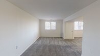 This single-floor unit offers a straightforward and functional layout, as illustrated by the 3D floor plan, which reveals a well-organized arrangement of living, sleeping, kitchen, and bathroom spaces. The living area is generously sized, featuring neutral cream-toned walls, grey wall-to-wall carpeting, and multiple windows fitted with horizontal blinds that allow natural light to fill the room. An open passage connects the living area to additional carpeted spaces, maintaining a cohesive flow throughout.

The kitchen is equipped with warm wood-toned cabinetry, light laminate countertops, a double-coil electric range, a full-size white refrigerator, and a single-basin sink. Light hardwood-style flooring and overhead fluorescent lighting give the kitchen a practical, clean appearance.

Multiple bedrooms are present, each finished with the same grey carpeting and cream walls found in the living area. Each bedroom includes at least one window with blinds, providing natural light and exterior views.

Two full bathrooms serve the unit, both featuring hardwood-style flooring, white vanities with mirrored medicine cabinets, a toilet, and a bathtub/shower combination. The clean white palette and efficient use of space make both bathrooms functional and well-maintained. Overall, the unit presents a clean, neutral aesthetic suitable for a variety of residents.