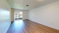 Located at 1416 Griffin Rd in Leesburg, FL, this 2-bedroom, 1-bathroom single-floor residence offers a practical and well-organized layout. Wood-look flooring runs throughout the home, providing a clean and cohesive aesthetic. The combined dining and living area is bright and open, with a sliding glass door that leads to a patio and frames views of the surrounding greenery, allowing natural light to fill the space. A textured ceiling adds subtle character throughout. The kitchen is efficiently designed, featuring white cabinetry with ample upper and lower storage, granite-look countertops, a double-basin sink with a window above it, and white appliances including a refrigerator and electric range. Both bedrooms are comfortably sized with wood-look flooring, neutral walls, and built-in closets — the primary bedroom offering additional square footage. The full bathroom is neatly appointed with a tub-shower combination, a single vanity, and wood-look flooring. Additional highlights include multiple closets for storage, two hallways for easy navigation, and a dedicated utility room. The overall ambiance is clean, bright, and move-in ready, making it a functional and comfortable home in Central Florida.