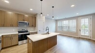Located at 196 Westfield Rd in Noblesville, Indiana, this well-appointed one-bedroom, one-bathroom unit offers a thoughtfully designed single-floor layout with a clean, contemporary aesthetic throughout.

The open-concept kitchen and living area serves as the heart of the space. The kitchen is outfitted with warm wood-toned cabinetry, stainless steel appliances including a refrigerator, range, and microwave, a white subway tile backsplash, and a central island with a white countertop and an undermount sink, illuminated by stylish pendant lighting. Light wood-style flooring runs throughout the main living areas, enhancing the bright and airy feel.

The living area benefits from generous natural light provided by large windows with blinds and a glass-paneled exterior door that opens to an outdoor view, giving the space an open, connected feel.

The bedroom features plush carpeting, a ceiling fan with light fixture, and a window that allows natural light and neighborhood views. The room offers a comfortable, private retreat.

The bathroom is finished with a glass-enclosed walk-in shower accented by vertically laid white tile, black hardware fixtures, and clean white walls for a modern, polished look.

Additional features include hallways, a dedicated closet for storage, and in-unit laundry as visible in the dollhouse view, rounding out this efficiently designed and stylish residence.