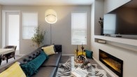 This single-floor residence in Sparks, Nevada offers a thoughtfully designed layout with a cohesive modern aesthetic throughout. The open-concept kitchen serves as a central highlight, featuring crisp white cabinetry extending to the ceiling, dark quartz countertops, stainless steel appliances including a French door refrigerator and gas range, and a substantial island with seating for multiple guests. Wood-look flooring flows seamlessly through the main living areas, enhancing the clean, contemporary feel.

The living room is an inviting retreat, anchored by a built-in fireplace and framed by multiple windows that draw in generous natural light. The bedrooms are carpeted for comfort, each offering ample natural light through large windows with blinds. The rooms provide a calm, neutral backdrop well-suited for relaxing.

The bathrooms are finished with light wood-tone cabinetry, dark countertops, and wood-look flooring. One bathroom features an elongated vanity with dual sinks and a walk-in shower, while another offers a single-sink vanity paired with a tub-shower combination. Both spaces maintain a clean, practical design consistent with the rest of the home's modern character.