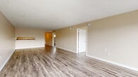 Located at 5211 N Tamiami Trail in Sarasota, Florida, this 2-bedroom, 2-bathroom residence offers a practical and comfortable single-floor layout. Wood-look luxury vinyl plank flooring runs throughout, providing a cohesive and easy-to-maintain finish across every room.

The combined kitchen and living area serves as the heart of the home. The kitchen is equipped with white shaker-style cabinetry, granite countertops, a stainless steel sink, and a stainless steel refrigerator with an in-door ice and water dispenser. A window over the sink allows natural light to brighten the workspace. The open living room is generously proportioned, featuring warm beige walls, a textured ceiling, and sliding glass doors that lead to a private balcony with outdoor views.

A hallway connects the living areas to the two bedrooms and two bathrooms. The primary bedroom offers a comfortable footprint with a closet and a window that brings in natural light. The second bedroom is similarly finished with matching flooring and neutral walls. Both bathrooms include a tub-shower combination, white vanity cabinetry, and wood-look flooring. A dedicated closet provides additional storage within the unit. The layout is efficient, making thoughtful use of every square foot throughout the home.