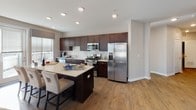 This thoughtfully designed 2-bedroom, 2-bathroom residence at REVA Main St in Rahway, NJ offers a single-floor open layout with modern finishes and generous living space throughout. The kitchen is a standout feature, showcasing rich dark cabinetry, a classic white subway tile backsplash, stainless steel appliances including a gas range, microwave, refrigerator, and dishwasher, along with a large center island with seating — ideal for casual dining and entertaining. The adjoining dining area benefits from large windows that flood the space with natural light, while the living room offers a comfortable, open atmosphere with hardwood-style flooring and recessed lighting. The primary bedroom is a serene retreat, highlighted by a stylish textured accent wall, a ceiling fan, large windows with outdoor views, and access to a walk-in closet. The second bedroom mirrors the same quality and comfort. Both bathrooms are finished with dark vanities, white countertops, and subway tile detailing, with one featuring a full soaking tub and shower combination. Hardwood-style flooring flows consistently throughout the home, complementing the neutral, contemporary color palette that defines the overall ambiance of this refined Rahway residence.