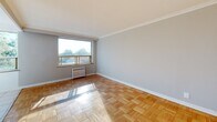 Located at 481 Vaughan Road in Toronto's midtown neighbourhood, this one-bedroom, one-bathroom apartment offers a well-organized and functional layout across a single floor. The spacious primary bedroom is a standout feature, showcasing classic parquet hardwood flooring, crown moulding, and soft grey walls that lend a clean, neutral aesthetic. A large window floods the room with natural light while offering pleasant views of the surrounding treetops and neighbourhood. A built-in sliding-door closet provides practical storage, and a radiator beneath the window contributes to a traditional, well-appointed character. The kitchen is efficiently designed in an L-shaped configuration, featuring white shaker-style cabinetry extending to the ceiling for ample storage, marble-patterned countertops, white subway tile backsplash, and light tile flooring. A white electric range and stainless steel sink complete the functional setup. The bathroom is clean and bright, finished with white tile throughout, and includes a full bathtub with overhead shower, a vanity with sink, and a toilet. Natural light enters through a frosted window, keeping the space feeling fresh and airy. Overall, the apartment presents a tidy, move-in-ready space with timeless finishes.