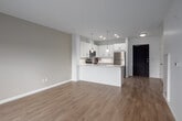 This well-designed 2-bedroom, 2-bathroom unit at 144 Watson Road North in Guelph offers a thoughtfully laid-out single-floor plan with a clean, contemporary aesthetic throughout. The open-concept kitchen and living area forms the heart of the unit, featuring a sleek peninsula with a light stone countertop, double stainless steel sink, and elegant pendant lighting overhead. White shaker-style cabinetry extends to the ceiling, complemented by a full suite of stainless steel appliances including a refrigerator, electric range, built-in microwave, and dishwasher. Recessed lighting and light-toned hardwood flooring run throughout, lending a bright, cohesive feel to the entire space. The living area opens to a balcony, allowing natural light and outdoor views to fill the room. The spacious primary bedroom offers generous proportions and access to views of the surrounding neighbourhood. The second bedroom features a large double-door closet and its own window with an urban outlook. Two well-appointed bathrooms serve the unit — one with a sleek glass-enclosed walk-in shower and white vanity, and the other with a full tiled tub-shower combination. Clean finishes, neutral tones, and modern fixtures are consistent throughout, creating a polished and functional living environment.