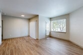 Located at 10571 Colorado Blvd in Thornton, CO, this single-floor, one-bedroom unit offers a thoughtfully designed layout with modern updates throughout. Light-toned luxury vinyl plank flooring flows seamlessly across the entire space, complementing the neutral wall palette and creating a bright, cohesive aesthetic.

The open-concept living, dining, and kitchen area forms the heart of the unit. The living room features a sliding glass door with vertical blinds that opens to natural greenery views, alongside a large window that fills the space with natural light. The kitchen is a standout, boasting crisp white shaker cabinets with matte black hardware, dark granite countertops, a subway tile backsplash, a deep undermount sink with a sleek black faucet, and a full suite of stainless steel appliances including a range, microwave, and refrigerator.

The primary bedroom is generously sized and includes a ceiling fan, a well-lit window, and direct access to a private bathroom and a closet. Additional closets provide ample storage throughout. A dedicated laundry area houses a full-size washer and dryer. The utility room and electrical panel are conveniently tucked away. The overall ambiance is clean, modern, and move-in ready.