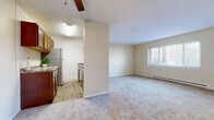 Located at 120 Meyer Rd in Buffalo, NY, this two-bedroom, one-bathroom unit offers a practical and comfortable layout across a single floor. The open living area is finished with neutral-toned carpet and benefits from natural light through a window, with a ceiling fan overhead for added comfort. A baseboard heater provides warmth during colder months.

The galley-style kitchen is well-equipped, featuring rich wood cabinetry, granite-style countertops, a stainless steel refrigerator, dishwasher, and range, all set atop durable wood-look vinyl flooring with a classic subway tile backsplash.

The spacious primary bedroom offers generous room for furnishings, including a wall-mounted air conditioning unit, with a second bedroom serving well as a guest room or home office. Both rooms are carpeted in neutral tones. A dedicated closet provides built-in shelving and hanging rods for ample storage.

The full bathroom includes a tiled tub-and-shower combination with decorative accent tiles, a granite-top vanity, and clean white tile flooring. A connecting hallway ties all rooms together efficiently, rounding out this well-organized and functional living space.