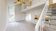 Located at 1521 Pine Valley Blvd in Ann Arbor, MI, this two-floor residence offers a smart, efficient layout spread across two levels. The main floor features a carpeted living room with vaulted ceiling height, a ceiling fan, and a staircase that draws natural light from an adjacent window — creating an open, airy atmosphere. The kitchen is thoughtfully designed with a pass-through counter, dark laminate countertops, white upper cabinetry, and built-in appliances, making efficient use of the available space. A full bathroom on this level is outfitted with a tub-shower combination enclosed by sliding glass doors and clean white tile surround. A hallway connects the main living areas and provides additional flow through the floor plan. The staircase leads to the upper level, where warm hardwood flooring and dramatically angled ceilings give the space a loft-like character. Exposed beams and bright white walls enhance the sense of openness, while a hallway with a window at the end brings in natural light. Throughout the residence, a consistent white color palette and clean finishes create a cohesive, move-in-ready environment well-suited to the Ann Arbor community.