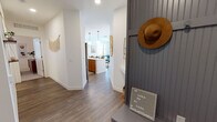 This single-story residence at Novel Midtown Phoenix blends contemporary design with warm, bohemian styling throughout. The entry hallway sets the tone with crisp white walls, wood-look plank flooring, and a charming beadboard accent wall featuring built-in storage.

The kitchen is a standout, showcasing floor-to-ceiling flat-front wood cabinetry, white quartz countertops, a subway tile backsplash, stainless steel appliances, and a generous island with pendant lighting overhead — ideal for both cooking and casual dining.

The living area is bright and welcoming, with multiple large windows framing urban skyline views and admitting generous natural light. A ceiling fan adds comfort, while wood-look flooring continues the cohesive aesthetic.

The bedrooms are carpeted and well-sized, each featuring ceiling fans, natural light, and access to dedicated bathrooms. The primary bath offers a double-sink vanity with wood cabinetry, white quartz counters, and a walk-in tiled shower. The secondary bath features a tub-shower combo with subway tile and a matching wood vanity.

Throughout, warm earth tones and modern finishes create a cohesive, inviting atmosphere.