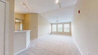 Located at 350 Covenant Blvd in Murfreesboro, TN, this single-story, 2-bedroom, 1-bathroom residence offers a well-designed layout with comfortable living spaces throughout. The open-concept living room is a standout feature, boasting soaring vaulted ceilings, plush carpeting, a ceiling fan, and a bank of large windows paired with a glass door that fills the room with natural light and views of surrounding greenery. Track lighting adds a modern touch to the space. The kitchen flows directly off the living area and features light wood cabinetry, white appliances including a range, microwave, and refrigerator, a double sink, and warm hardwood-style flooring beneath a pendant light fixture. Both bedrooms are carpeted and finished in neutral tones, with the primary bedroom offering two closets and ample space. The second bedroom also benefits from dual windows that bring in natural light. The full bathroom includes a tub-shower combination and tile flooring. A dedicated laundry room with side-by-side washer and dryer hookups, tile floors, and additional shelving adds everyday convenience. Warm beige walls and white trim carry throughout the home, creating a cohesive and inviting ambiance.