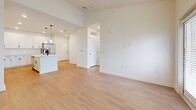 This 750-square-foot, one-bedroom, one-bathroom apartment in North Augusta, SC, delivers a clean and modern living experience across a single well-organized floor. Light wood-tone luxury vinyl plank flooring runs throughout the entire unit, complementing a bright, neutral color palette of crisp whites and warm beiges.

The kitchen is a standout feature, boasting white shaker-style cabinetry extending floor to ceiling, white subway tile backsplash, and white quartz countertops. A central island with a matte black faucet and sink serves as both a prep station and a casual gathering point, illuminated by two pendant lights. Stainless steel appliances, including a refrigerator, range, and over-range microwave, complete the space.

The open-concept living room features vaulted ceilings, a ceiling fan, and large windows with a sliding glass door that invites abundant natural light and outdoor views. The 180-square-foot primary bedroom mirrors this brightness with tall ceilings, a ceiling fan, and sizable windows overlooking the surrounding neighborhood.

The bathroom features white shaker vanity cabinetry, a white quartz countertop, and matte black hardware, consistent with the unit's cohesive modern aesthetic. The overall ambiance is clean, bright, and move-in ready.