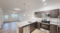 This well-appointed 2-bedroom, 2-bathroom single-story home at 25100 Ashton Cir in Frankford, Delaware offers a thoughtfully designed layout with modern finishes throughout. Light wood-look flooring runs continuously across the home, creating a cohesive and clean aesthetic. The open-concept kitchen, dining, and living area serves as the heart of the home. The kitchen is equipped with dark espresso shaker cabinets, granite countertops, a peninsula island with an undermount sink and built-in dishwasher, and a full suite of stainless steel appliances including a refrigerator, range, and microwave. Pendant lighting above the island adds a contemporary touch, while recessed lighting and a ceiling fan illuminate the adjacent living and dining space. A hallway entry features built-in wall hooks for added convenience. Both bedrooms offer light-filled interiors with ceiling fans, natural light from windows with blinds, and easy access to closets. The primary bedroom is comfortably sized with its own dedicated closet. The bathrooms are clean and functional, with one featuring a glass-door shower. A dedicated laundry area includes a full-size washer and dryer with overhead wire shelving for storage.