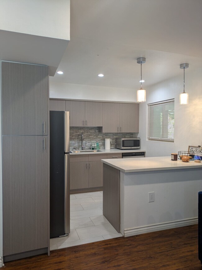 Cocina moderna con gabinetes estilo europeo, encimeras de cuarzo y electrodomésticos nuevos de acero inoxidable. - 5652 Yolanda Ave
