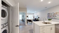 Located at 1179 E Main St in Columbus, Ohio, this thoughtfully designed one-bedroom, one-bathroom unit offers a modern and functional layout across a single floor. The open-concept living and kitchen area serves as the heart of the space, where light wood-tone flooring, recessed lighting, and neutral walls create a clean, contemporary atmosphere. The kitchen is well-appointed with white cabinetry, stainless steel appliances including a refrigerator, range, microwave, and dishwasher, and a white quartz countertop island with bar seating — ideal for casual dining or entertaining. Adjacent to the kitchen, the living room is bright and welcoming, featuring large windows with roller shades that allow natural light to filter in, along with direct access to an exterior door. The bedroom offers plush carpeting, a generous window, and a closet, providing a comfortable and private retreat. The full bathroom is finished with light wood-look flooring, a white vanity with ample storage, and a walk-in glass-enclosed shower with matte black fixtures. Throughout the unit, the consistent use of soft neutral tones, modern fixtures, and clean lines contributes to a cohesive, move-in-ready aesthetic.