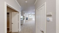 Located along Aliso Creek Road in Aliso Viejo, California, this single-floor, 2-bedroom, 1-bathroom residence offers a thoughtfully organized layout across a comfortable footprint. The open-concept living room serves as the heart of the home, featuring a corner fireplace with a white mantel surround, crown molding, a ceiling fan with light fixture, and plush wall-to-wall carpeting. Multiple windows fitted with horizontal blinds invite natural light and provide views of the surrounding greenery, creating a bright and airy atmosphere.

The kitchen is efficiently designed in a U-shaped configuration, featuring white cabinetry, gray countertops, a stainless steel undermount sink, a stainless steel dishwasher, and a subtle tile backsplash. A window above the sink provides additional natural light.

Both bedrooms offer carpeted flooring, neutral-toned walls, and windows with outdoor views. The primary bedroom includes a ceiling fan, while the secondary bedroom benefits from corner windows. A dedicated walk-in closet with wire shelving and hanging rods provides ample storage.

The full bathroom features wood-look plank flooring, a white vanity with gray countertop and large mirror, and a full-size bathtub with shower.