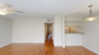 This well-appointed 2-bedroom, 1-bathroom residence in Baton Rouge, Louisiana offers a thoughtfully designed single-floor layout that maximizes comfort and functionality. Rich hardwood flooring flows throughout the main living areas, complemented by neutral walls and crown molding that lend a clean, polished aesthetic. The open living room is bathed in natural light from large windows flanked by white blinds, with a ceiling fan adding both style and practicality. It connects seamlessly to the kitchen, which features a granite countertop breakfast bar, subway tile backsplash, light wood cabinetry, and white appliances — an efficient and attractive space for everyday cooking. A hallway leads to the two bedrooms, each offering hardwood floors and ample space. The primary bedroom includes a dedicated closet with full-width hanging rods for generous storage. The full bathroom is finished with granite countertops, white shaker-style cabinetry, and a tub-shower combination with clean tile surround. A dedicated in-unit laundry room accommodates a full-size washer and dryer with overhead shelving, adding exceptional convenience. The overall ambiance is light, clean, and move-in ready — a practical and comfortable home in the heart of Baton Rouge.