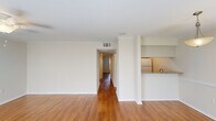 This well-appointed 2-bedroom, 1-bathroom residence in Baton Rouge, Louisiana offers a thoughtfully designed single-floor layout that maximizes comfort and functionality. Rich hardwood flooring flows throughout the main living areas, complemented by neutral walls and crown molding that lend a clean, polished aesthetic. The open living room is bathed in natural light from large windows flanked by white blinds, with a ceiling fan adding both style and practicality. It connects seamlessly to the kitchen, which features a granite countertop breakfast bar, subway tile backsplash, light wood cabinetry, and white appliances — an efficient and attractive space for everyday cooking. A hallway leads to the two bedrooms, each offering hardwood floors and ample space. The primary bedroom includes a dedicated closet with full-width hanging rods for generous storage. The full bathroom is finished with granite countertops, white shaker-style cabinetry, and a tub-shower combination with clean tile surround. A dedicated in-unit laundry room accommodates a full-size washer and dryer with overhead shelving, adding exceptional convenience. The overall ambiance is light, clean, and move-in ready — a practical and comfortable home in the heart of Baton Rouge.
