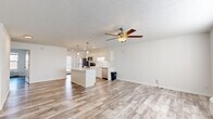 Located at 2880 Majestic Ln in Lafayette, Indiana, this one-bedroom, one-bathroom unit offers a well-designed single-floor layout that maximizes functionality and comfort. The open-concept living and kitchen area serves as the heart of the home, featuring light-toned luxury vinyl plank flooring, crisp white walls, and a textured ceiling with a ceiling fan and light fixture. The kitchen is thoughtfully appointed with white shaker-style cabinetry, a light quartz countertop, a center island with pendant lighting, and a full suite of stainless steel appliances including a refrigerator, electric range, over-the-range microwave, and dishwasher. An adjacent open closet provides convenient pantry storage. The living area is bright and airy, enhanced by natural light from a window and a wall-mounted HVAC unit. The bedroom is a comfortable, well-proportioned retreat with its own ceiling fan, a natural light window, and a double-door closet. The bathroom features a walk-in shower, a white vanity, and wood-look tile flooring. The unit also includes a dedicated laundry area, completing a practical and move-in-ready floor plan.