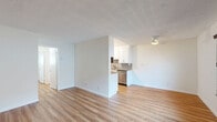 Located at 1929 E Appleton St in Long Beach, California, this 2-bedroom, 1-bathroom single-floor residence offers a clean, functional layout with consistent warm-toned hardwood-style flooring throughout. The living room serves as the welcoming heart of the home, featuring a striking black front door with a decorative glass insert, a large window fitted with horizontal blinds that allows generous natural light to fill the space, and crisp white walls that enhance the bright, open atmosphere. The kitchen is positioned adjacent to the living area with a peninsula counter, providing a practical and connected layout. Both bedrooms are well-proportioned, with the primary bedroom featuring full mirrored sliding closet doors that add depth and reflect light throughout the room. The second bedroom also benefits from a window with blinds, maintaining a consistent feel across the space. A hallway connects the bedrooms to the shared bathroom, which is tastefully finished with large-format gray tile surrounding a full soaking tub and shower combination, complete with a sleek frameless sliding glass door and brushed nickel fixtures. The textured ceilings, clean white baseboards, and cohesive flooring tie the entire space together, creating a tidy and move-in ready home in the heart of Long Beach.