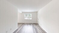 Located at 819 Forrest Dr in Newport News, Virginia, this well-appointed two-bedroom, one-bathroom single-floor residence offers a clean, modern aesthetic throughout. Light gray luxury vinyl plank flooring runs consistently across every room, creating a cohesive and contemporary feel.

The living room is bright and open, featuring a large window that invites natural light and offers views of the surrounding greenery. The galley-style kitchen is thoughtfully updated with gray shaker cabinets, white quartz countertops, a classic subway tile backsplash, a stainless steel sink, and stainless steel appliances including a refrigerator and range, all beneath recessed overhead lighting.

The spacious primary bedroom provides generous room for furnishings, while the second bedroom also offers comfortable proportions, each brightened by natural light from well-placed windows. Four closets distributed throughout the home ensure ample storage. A connecting hallway links the bedrooms to the full bathroom, which features a tub-shower combination with stylish textured white tile surround and chrome fixtures. The dining room provides a dedicated space for meals, completing the practical and efficient layout of this move-in-ready home.