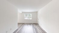 Located at 819 Forrest Dr in Newport News, Virginia, this well-appointed two-bedroom, one-bathroom single-floor residence offers a clean, modern aesthetic throughout. Light gray luxury vinyl plank flooring runs consistently across every room, creating a cohesive and contemporary feel.

The living room is bright and open, featuring a large window that invites natural light and offers views of the surrounding greenery. The galley-style kitchen is thoughtfully updated with gray shaker cabinets, white quartz countertops, a classic subway tile backsplash, a stainless steel sink, and stainless steel appliances including a refrigerator and range, all beneath recessed overhead lighting.

The spacious primary bedroom provides generous room for furnishings, while the second bedroom also offers comfortable proportions, each brightened by natural light from well-placed windows. Four closets distributed throughout the home ensure ample storage. A connecting hallway links the bedrooms to the full bathroom, which features a tub-shower combination with stylish textured white tile surround and chrome fixtures. The dining room provides a dedicated space for meals, completing the practical and efficient layout of this move-in-ready home.