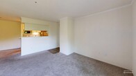 This thoughtfully designed one-bedroom, one-bathroom residence on Germantown Pike in Lafayette Hill, PA, offers a comfortable and functional layout across a single floor. The open-concept living and dining area is finished with neutral wall-to-wall carpeting and crown molding, creating a clean, welcoming atmosphere. A pass-through counter connects the living space to the galley-style kitchen, which features white shaker cabinetry with modern bar-pull hardware, white quartz countertops, a subway tile backsplash, wood-look tile flooring, and a full suite of stainless steel appliances including a refrigerator, electric range, and dishwasher. A louvered door leads to additional in-unit storage. The living area opens to a private balcony through sliding glass doors, offering pleasant views of mature greenery. The spacious bedroom is carpeted and filled with natural light from a large window, with easy access to a dedicated closet and the full bathroom. The bathroom is a standout feature, showcasing large-format marble-look tile surrounding a soaking tub and shower combination, complemented by wood-look flooring. A hallway connects all areas of the home, completing this efficiently organized residence.