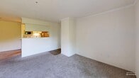 This thoughtfully designed one-bedroom, one-bathroom residence on Germantown Pike in Lafayette Hill, PA, offers a comfortable and functional layout across a single floor. The open-concept living and dining area is finished with neutral wall-to-wall carpeting and crown molding, creating a clean, welcoming atmosphere. A pass-through counter connects the living space to the galley-style kitchen, which features white shaker cabinetry with modern bar-pull hardware, white quartz countertops, a subway tile backsplash, wood-look tile flooring, and a full suite of stainless steel appliances including a refrigerator, electric range, and dishwasher. A louvered door leads to additional in-unit storage. The living area opens to a private balcony through sliding glass doors, offering pleasant views of mature greenery. The spacious bedroom is carpeted and filled with natural light from a large window, with easy access to a dedicated closet and the full bathroom. The bathroom is a standout feature, showcasing large-format marble-look tile surrounding a soaking tub and shower combination, complemented by wood-look flooring. A hallway connects all areas of the home, completing this efficiently organized residence.