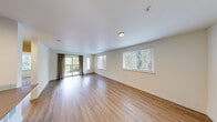 Located along the scenic West Lake Sammamish Parkway in Issaquah, WA, this well-appointed 2-bedroom, 2-bathroom residence offers a thoughtfully designed single-floor layout. The open living area features warm hardwood-style flooring, large windows, and a sliding glass door leading to a private balcony, filling the space with natural light and views of surrounding Pacific Northwest greenery. A hallway connects the living area to the rest of the home, providing a clear and functional flow throughout. The kitchen is outfitted with rich dark wood cabinetry, stainless steel appliances including a refrigerator, range, and microwave, ample counter space, and light wood-style flooring, creating a modern and efficient cooking environment. Both bedrooms are carpeted for comfort and equipped with ceiling fans. The spacious primary bedroom includes a generous closet, while the second bedroom also features a closet and a large window overlooking the tree-lined surroundings. Each of the two bathrooms is finished with wood-tone vanity cabinetry, a full tub-shower combination, light wood-style tile flooring, and a large mirror. A dedicated utility room completes the layout, adding practical storage and convenience to this well-rounded Issaquah residence.