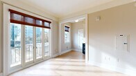 Located in the heart of Portland at 1211 SW Broadway, this one-bedroom, one-bathroom residence offers a thoughtfully arranged layout across a single floor. Light-toned hardwood flooring runs throughout, creating a warm and cohesive aesthetic that ties each room together.

The living room is bathed in natural light, featuring crown molding, a ceiling fan, and track lighting that add classic architectural character. Large French doors open to an urban balcony, framing sweeping views of downtown Portland and filling the space with abundant daylight. A cast-iron radiator adds a charming historic touch.

The kitchen stands out with two-toned cabinetry — crisp white upper cabinets paired with bold navy lower drawers — complemented by white subway tile backsplash, light stone countertops, and a full suite of stainless steel appliances including a range, microwave, and refrigerator.

The bedroom is generously sized, with direct access to the bathroom and a dedicated closet featuring built-in shelving, hanging rods, and drawer storage for ample organization.

The bathroom exudes classic charm with floor-to-ceiling white subway tile, a teal accent border, a soaking tub, and a bright window that provides natural ventilation. A hallway connects each area efficiently, completing this well-designed urban residence.