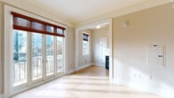 Located in the heart of Portland at 1211 SW Broadway, this one-bedroom, one-bathroom residence offers a thoughtfully arranged layout across a single floor. Light-toned hardwood flooring runs throughout, creating a warm and cohesive aesthetic that ties each room together.

The living room is bathed in natural light, featuring crown molding, a ceiling fan, and track lighting that add classic architectural character. Large French doors open to an urban balcony, framing sweeping views of downtown Portland and filling the space with abundant daylight. A cast-iron radiator adds a charming historic touch.

The kitchen stands out with two-toned cabinetry — crisp white upper cabinets paired with bold navy lower drawers — complemented by white subway tile backsplash, light stone countertops, and a full suite of stainless steel appliances including a range, microwave, and refrigerator.

The bedroom is generously sized, with direct access to the bathroom and a dedicated closet featuring built-in shelving, hanging rods, and drawer storage for ample organization.

The bathroom exudes classic charm with floor-to-ceiling white subway tile, a teal accent border, a soaking tub, and a bright window that provides natural ventilation. A hallway connects each area efficiently, completing this well-designed urban residence.