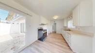 Located at 17902 Bell Cir in Huntington Beach, CA, this single-story, 3-bedroom, 2-bathroom home offers a clean, functional layout with a bright and airy aesthetic throughout. Light wood-style flooring runs through the main living and kitchen areas, creating a cohesive and modern feel.

The galley-style kitchen is well-appointed with crisp white cabinetry, light countertops, a stainless steel gas range, and a built-in sink with a window for natural light. A sliding glass door provides direct access to the outdoor area, allowing for seamless indoor-outdoor flow.

The living room is open and sun-filled, with a sliding glass door that invites abundant natural light and outdoor views. Light wood flooring and clean white walls contribute to the room's bright, welcoming atmosphere.

Each of the three bedrooms features plush carpeting, ceiling fans, and windows that allow natural light to filter in. The bedrooms also include sliding closet doors, offering practical storage solutions. The primary bedroom provides a comfortable and generously sized personal retreat.

The two bathrooms are finished with light wood-style flooring, white cabinetry, and clean fixtures, maintaining the home's consistent, neutral aesthetic. Multiple hallways connect the rooms efficiently throughout the single-floor layout.