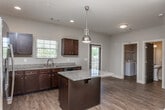 Located at 1805 Shiloh Rd NW in Kennesaw, Georgia, this two-story home offers a well-designed layout with quality finishes throughout. The main level features an open-concept living and kitchen area with warm hardwood-style flooring that flows seamlessly between spaces. The kitchen is a standout, equipped with rich dark espresso cabinetry, granite countertops, stainless steel appliances including a refrigerator, range, microwave, and dishwasher, and a central island with pendant lighting. A window above the sink allows natural light to brighten the space. The main level also includes a convenient half bath with a pedestal sink and hardwood-style flooring. Upstairs, the bedrooms feature plush carpeting, ceiling fans, and windows that invite natural light. At least one bedroom includes a private en-suite bathroom, while additional full bathrooms feature dark vanity cabinetry with granite countertops and tub-shower combinations. Neutral wall tones and clean finishes are consistent throughout, contributing to a cohesive and move-in-ready aesthetic. The home's layout balances open communal spaces with comfortable private retreats, making it a functional and attractive residence in the Kennesaw area.