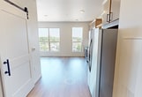 This 490 square foot apartment in Fargo, ND, presents a harmonious blend of functionality and contemporary design. The open floor plan maximizes space utilization, creating a sense of airiness throughout the single-story dwelling. Large windows dominate one wall, flooding the interior with natural light and offering expansive views of the surrounding area.

The kitchen is a standout feature, boasting sleek stainless steel appliances, including a refrigerator, built-in microwave, and oven. Light-toned cabinetry with modern hardware provides ample storage, while a white tile backsplash adds a touch of sophistication. The kitchen's layout is designed for efficiency, with a seamless flow that integrates it into the living space.

The bathroom continues the modern aesthetic with a floating vanity, large mirror, and crisp white fixtures. Wood-look flooring extends throughout the apartment, including the bathroom, lending warmth and continuity to the space. Recessed lighting fixtures are strategically placed to provide even illumination.

Despite its compact size, the apartment doesn't compromise on style or amenities. The thoughtful design creates distinct areas for living, dining, and sleeping within the open layout. High ceilings enhance the sense of spaciousness, while the neutral color palette offers a canvas for personalization. This apartment exemplifies efficient urban living with a contemporary flair.