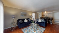 This single-story residence offers a thoughtfully organized layout encompassing two bedrooms and two full bathrooms. The living area serves as the central gathering space, featuring rich hardwood flooring, crown molding, and warm neutral-toned walls. A breakfast bar with granite countertop connects the living space to the galley-style kitchen, providing both a casual dining option and a natural transition between areas.

The kitchen is designed for efficient use of space, with white cabinetry lining both sides, dark granite countertops, tile flooring, and a full suite of appliances including a dishwasher. Ample cabinet storage is provided above and below the counters.

The primary bedroom features hardwood flooring, crown molding, and a window that admits natural light. The second bedroom also offers hardwood floors, crown molding, and a window, with flexible accommodations. Both bathrooms are similarly appointed, each featuring tile flooring, granite-topped vanities with white cabinetry, and a tub-shower combination with tile surround. The consistent use of crown molding, hardwood flooring, and neutral tones throughout creates a cohesive and comfortable ambiance across the entire residence.