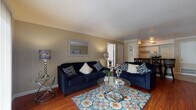 This single-story residence offers a thoughtfully organized layout encompassing two bedrooms and two full bathrooms. The living area serves as the central gathering space, featuring rich hardwood flooring, crown molding, and warm neutral-toned walls. A breakfast bar with granite countertop connects the living space to the galley-style kitchen, providing both a casual dining option and a natural transition between areas.

The kitchen is designed for efficient use of space, with white cabinetry lining both sides, dark granite countertops, tile flooring, and a full suite of appliances including a dishwasher. Ample cabinet storage is provided above and below the counters.

The primary bedroom features hardwood flooring, crown molding, and a window that admits natural light. The second bedroom also offers hardwood floors, crown molding, and a window, with flexible accommodations. Both bathrooms are similarly appointed, each featuring tile flooring, granite-topped vanities with white cabinetry, and a tub-shower combination with tile surround. The consistent use of crown molding, hardwood flooring, and neutral tones throughout creates a cohesive and comfortable ambiance across the entire residence.