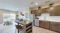 This well-appointed 2-bedroom, 3-bathroom residence in Rochester, MN offers a thoughtfully designed single-floor layout that maximizes comfort and functionality. The open-concept kitchen and living area serves as the heart of the home, featuring rich warm-toned cabinetry, a classic white subway tile backsplash, light quartz countertops, and a full suite of stainless steel appliances including a refrigerator, dishwasher, range, and microwave. Light wood-style plank flooring runs throughout the main living areas, adding warmth and continuity to the space. The living room is bright and inviting, highlighted by a sliding glass door that opens to a private patio and offers views of the surrounding landscape. The primary bedroom is a comfortable retreat, complete with an en-suite bathroom featuring wood-toned cabinetry and direct access to a walk-in closet. The second bedroom features plush carpeting, a ceiling fan, and a natural light-filled window. Three full bathrooms ensure ample convenience for residents and guests alike. Throughout the residence, neutral tones and recessed lighting create a clean, modern ambiance that is both practical and welcoming — an ideal home in the heart of Rochester.
