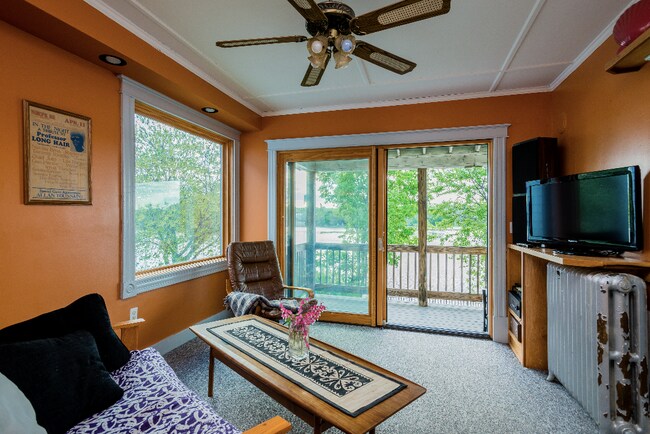 Our beautiful riverside living room features full glass windows and sliding door to a private patio! - 803 1st Ave