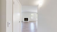 Located at 3362 Honeybrook Way in Ontario, CA, this single-story 2-bedroom, 2-bathroom home offers a clean, modern aesthetic throughout. The open-concept layout seamlessly connects the living room, dining area, and kitchen, creating a bright and functional shared space. The living room is a standout, featuring a white-surround fireplace flanked by windows that invite natural light, with a sliding glass door providing direct access to a private balcony with outdoor views. Light-toned wood-style flooring runs throughout, lending warmth and visual continuity across the home. The kitchen is well-equipped with white shaker cabinetry, light stone countertops, stainless steel appliances including a range and microwave, and a deep single-basin sink with a modern spring-neck faucet. Both bedrooms are comfortably sized with the same light flooring and crisp white walls; the primary bedroom includes a closet and an en-suite bathroom with a single-sink vanity and a glass-enclosed walk-in shower. The second bathroom offers a full tub-shower combination with a white vanity. Additional conveniences include a dedicated laundry area and a hallway connecting all private rooms. The overall ambiance is bright, minimal, and move-in ready.